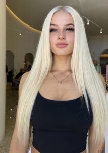 Platinum blonde straight hair by Melbourne blonde specialist, woman in black tank top.