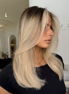 Side view of face-framing blonde highlights, showcasing our expert hair styling.