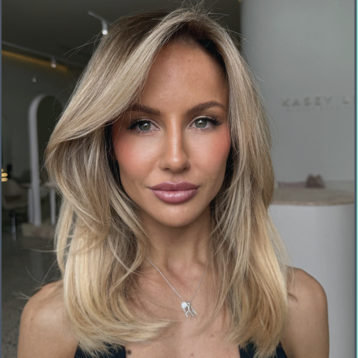 Wavy long blonde hair styled to the side, featuring the Platinum Blonde Service by blonde hairdresser in Melbourne.
