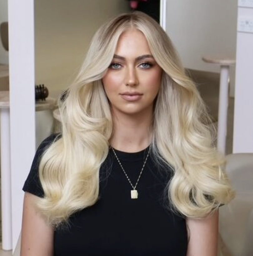 Wavy long blonde hair styled to the side, featuring the Platinum Blonde Service by blonde hairdresser in Melbourne.