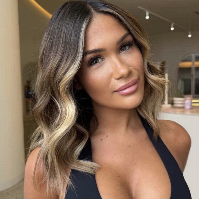 Wavy long blonde hair styled to the side, featuring the Platinum Blonde Service by blonde hairdresser in Melbourne.