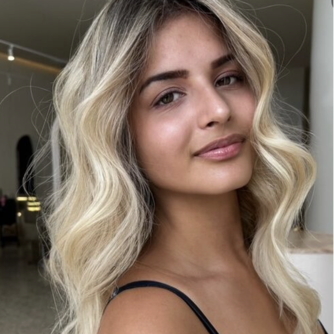 Wavy long blonde hair styled to the side, featuring the Platinum Blonde Service by blonde hairdresser in Melbourne.